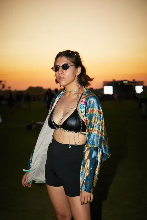 Con un look más indie, ella fue por un top negro con cadenas, un kimono para darle un toque de color y unos lentes noventosos. Además, combinó los aros con las cadenas y agregó un poco de glitter, algo que se vio mucho. Con un look más indie, ella fue por un top negro con cadenas, un kimono para darle un toque de color y unos lentes noventosos. Además, combinó los aros con las cadenas y agregó un poco de glitter, algo que se vio mucho.