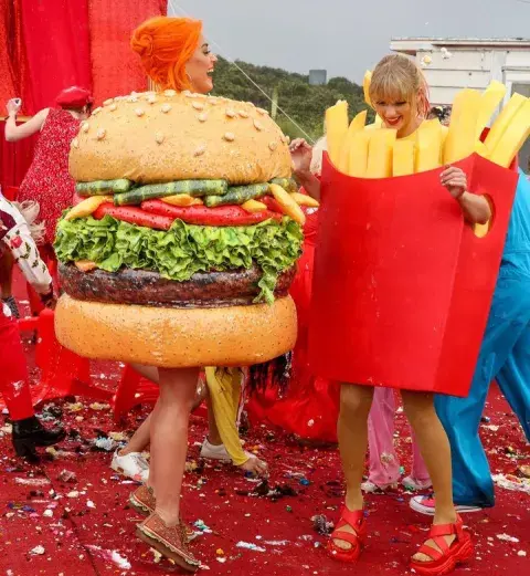 Katy Perry y Taylor Swift disfrazadas de hamburguesa y papas fritas para una de las tomas del videoclip "You Need To Calm Down". Katy Perry y Taylor Swift disfrazadas de hamburguesa y papas fritas para una de las tomas del videoclip "You Need To Calm Down".