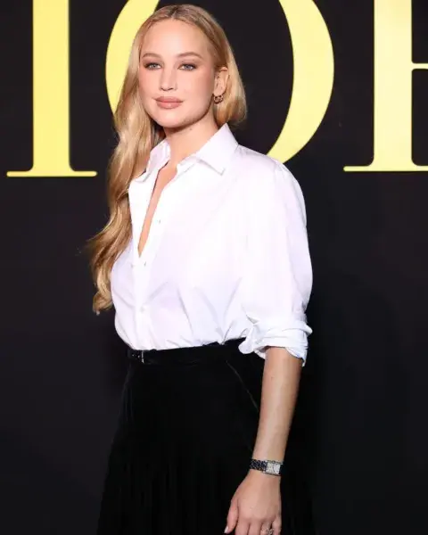 Combinándola con una falda larga, Jennifer Lawrence llevó una camisa blanca de corte clásico. Combinándola con una falda larga, Jennifer Lawrence llevó una camisa blanca de corte clásico.