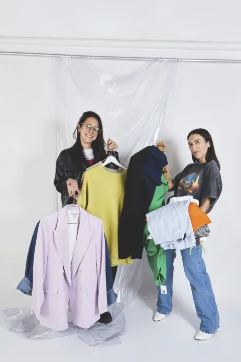 Dos chicas con perchas en la mano. Dos chicas con perchas en la mano.