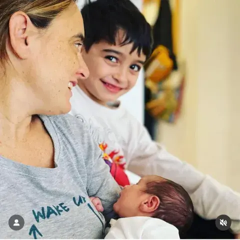 Juli, con Vito en brazos; a su lado Tiziano, que la mira y sonríe con picardía.
