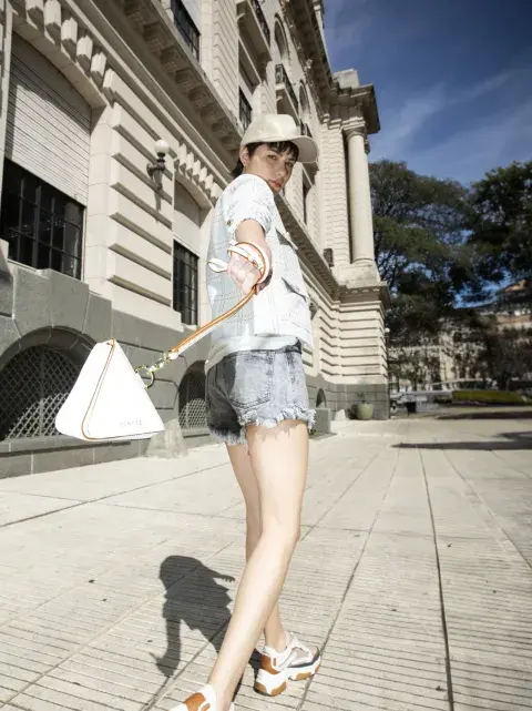 CHAQUETA SÍMIL TWEED, REMERA Y SHORT DE DENIM (RENNER, $53.390, $17.190 Y $12.390), ZAPATILLAS (SHELOSOPHY, $64.900), MINIBAG (SENTEZ, $54.500), GORRA (COMPAÑÍA DE SOMBREROS, $16.500).