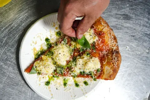 Slide de pizza con burrata, mile y limón de Kali. Slide de pizza con burrata, mile y limón de Kali.