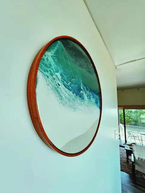 El cuadro redondo de la artista Catalina Iribarne (@surlamar_) también remite al espíritu surfer de la casita.
