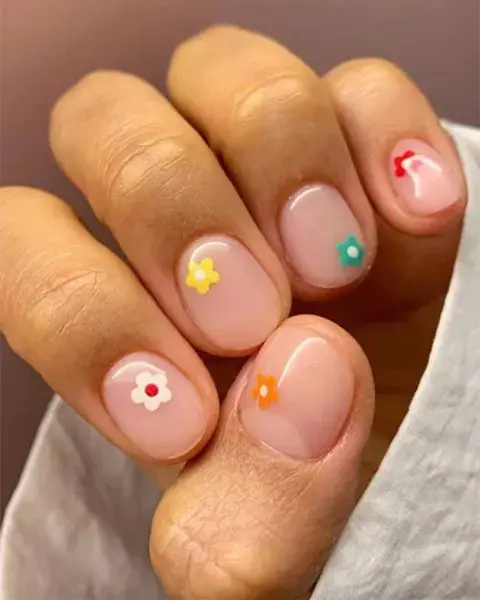 Súper delicado, sobre un esmalte transparente una pequeña flor. ¿El detalle? Cambiar el color y el lugar.