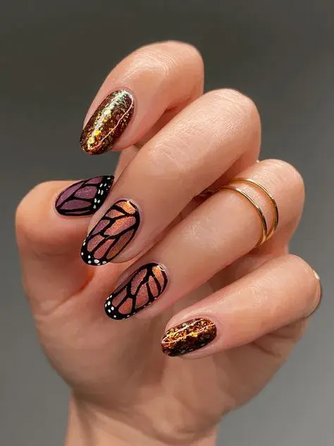 Con brillos y efecto holograma. Lo interesante de este diseño es que la mariposa no está dibujada en su totalidad, sino sólo la trama de sus alas.