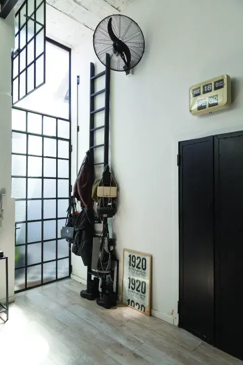 la escalera como perchero para sus carteras favoritas y un objeto que ama: el reloj antiguo con día y hora. 