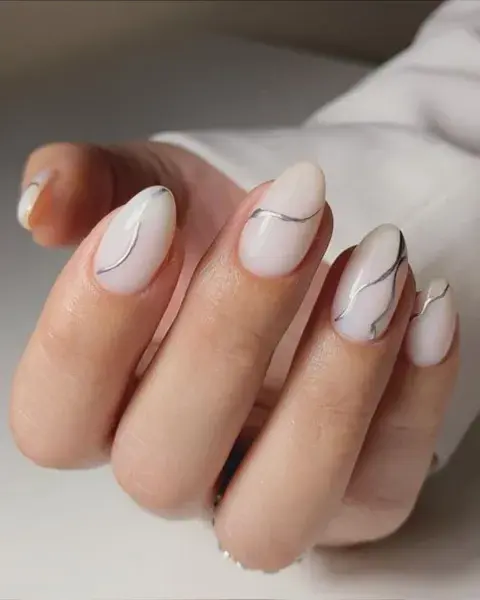 El plateado genera un re buen contraste en las uñas con base "milky". Este diseño con ondas es muy sutil y elegante. El plateado genera un re buen contraste en las uñas con base "milky". Este diseño con ondas es muy sutil y elegante.