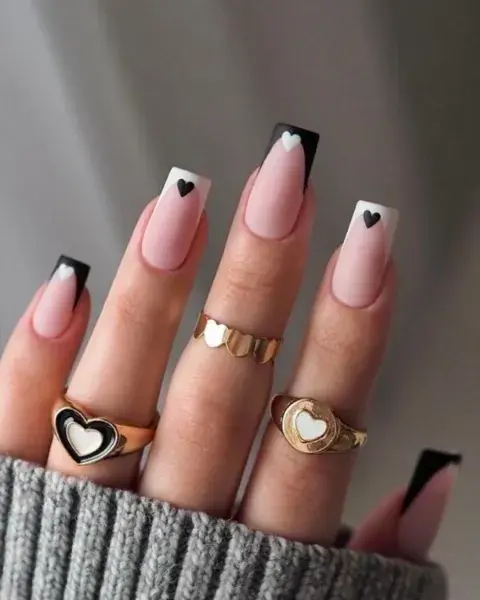 Sobre una base nude mate y con las uñas cuadradas, sumás francesitas y lo combinás con corazones.