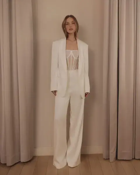 Este diseño no es técnicamente un mono, pero da ese efecto visual. Un traje sastrero divino en off white, con corset con transparencias. ¡Súper elegante!