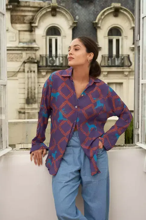 Camisa estampada, con fondo morado y detalles en turquesa y marrón. Es de @mila.chemin