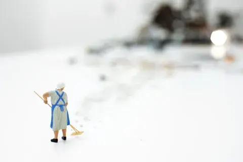 Una escena en miniatura: la mujer barre los restos de una vajilla de porcelana rota Una escena en miniatura: la mujer barre los restos de una vajilla de porcelana rota