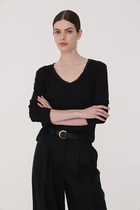 Una reversión de la clásica remera negra, con cuello escote en V adornado con galón de piedras. @thecream.arg Una reversión de la clásica remera negra, con cuello escote en V adornado con galón de piedras. @thecream.arg