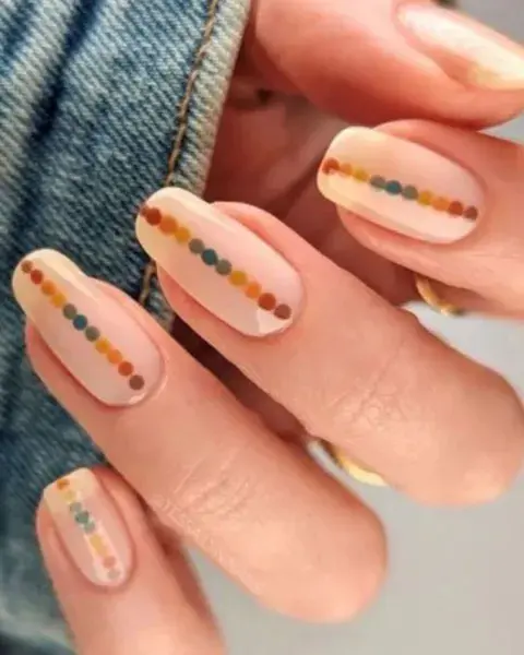 Sobre una base milky, creas un dot nail art en tonos verdes y marrones.