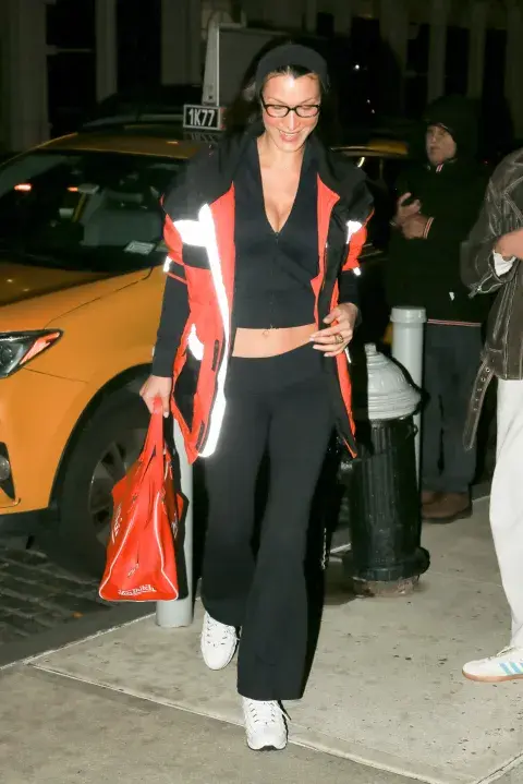 Bella Hadid con un look sporty: top, flared leggings y chaqueta deportiva. Bella Hadid con un look sporty: top, flared leggings y chaqueta deportiva.