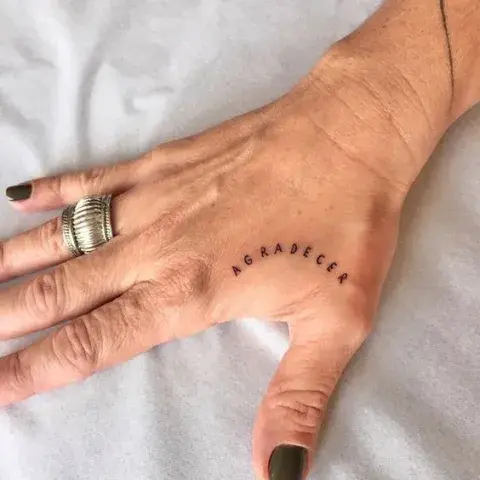 tatuaje en la mano que dice "agradecer" tatuaje en la mano que dice "agradecer"