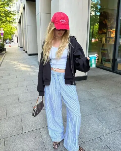 Una mujer en la calle usando pantalón de pijama. Una mujer en la calle usando pantalón de pijama.