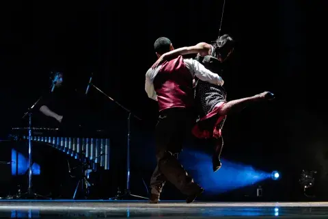 Los bailarines realizan acrobacias aéreas que desafían la gravedad sostenidos por arneses. Los bailarines realizan acrobacias aéreas que desafían la gravedad sostenidos por arneses.
