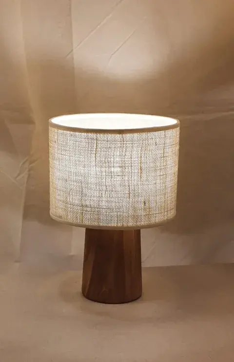La lámpara Cono de Silva & Co tiene base de madera de olmo y pantalla en arpillera natural La lámpara Cono de Silva & Co tiene base de madera de olmo y pantalla en arpillera natural