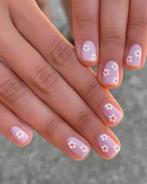  Foto de una mano de mujer con nail art de margaritas.