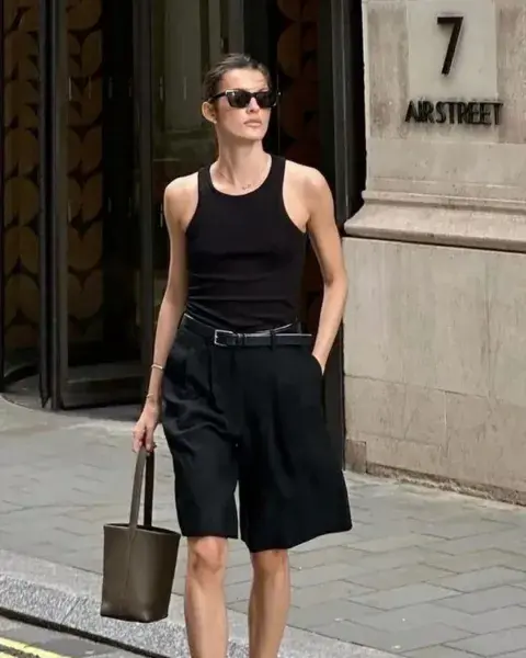 Una mujer en la calle usando bermudas. Una mujer en la calle usando bermudas.