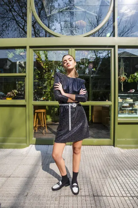 Una mujer posando con un vestido negro de brillos Una mujer posando con un vestido negro de brillos