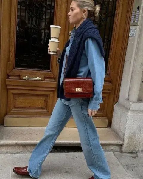 Foto de una mujer en la calle usando un suéter al hombro. Foto de una mujer en la calle usando un suéter al hombro.