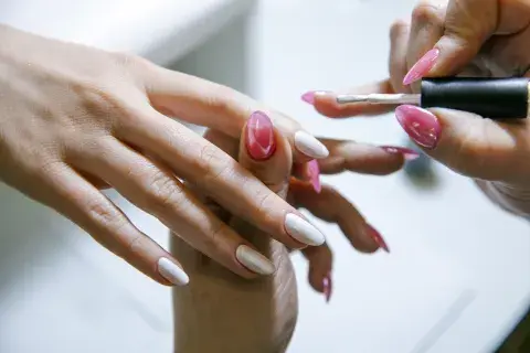 Una mujer pintándose las uñas Una mujer pintándose las uñas