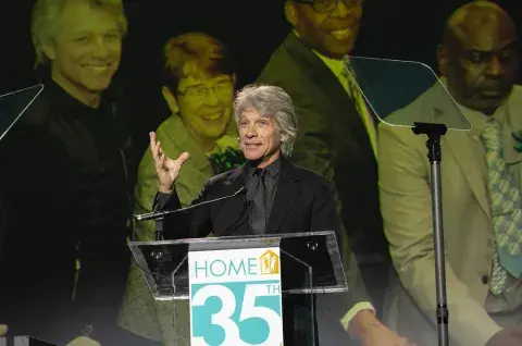 Foto de Jon Bon Jovi dando un discurso sobre su fundación humanitaria.