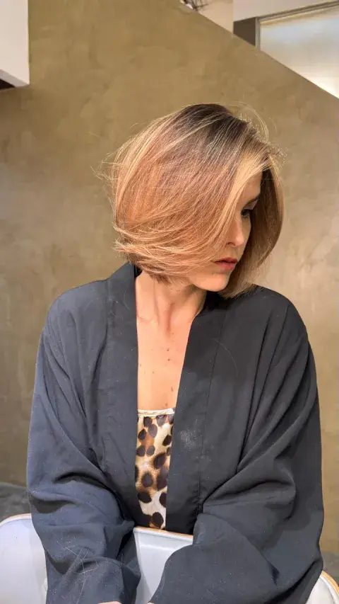 Una mujer posando con su nuevo corte de cabello Una mujer posando con su nuevo corte de cabello