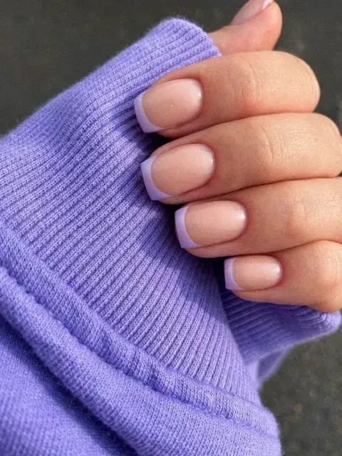Foto de una mano de mujer con manicura francesa de color. Foto de una mano de mujer con manicura francesa de color.