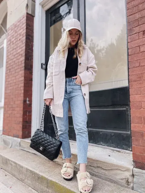 Chica posando muy canchera con una cartera negra, jeans claros y sandalias Birkenstock Chica posando muy canchera con una cartera negra, jeans claros y sandalias Birkenstock
