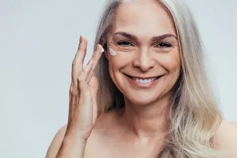 Mujer colocándose una crema. Mujer colocándose una crema.