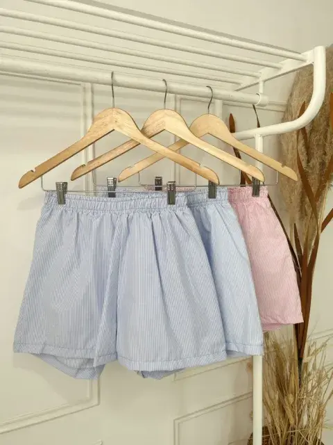 Foto de 3 shorts rayados colgados en perchas. Foto de 3 shorts rayados colgados en perchas.