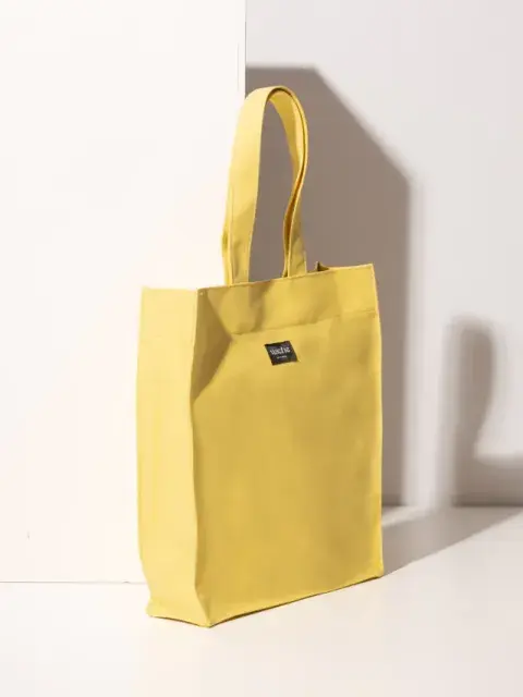 Foto de una tote bag amarilla. Foto de una tote bag amarilla.