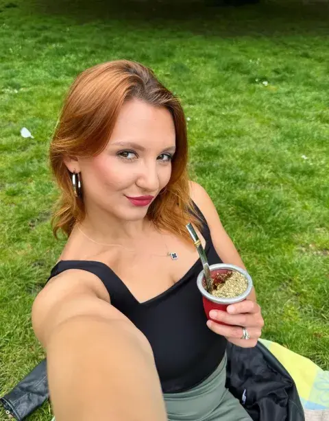 Una joven tomando mate en un parque Una joven tomando mate en un parque
