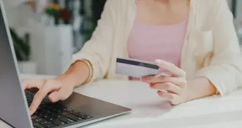 Una mujer haciendo una compra online con su tarjeta de crédito Una mujer haciendo una compra online con su tarjeta de crédito