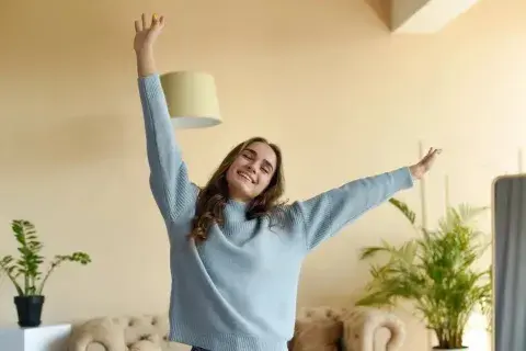 Una mujer en su casa estirándose Una mujer en su casa estirándose