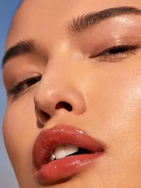 Foto de una mujer usando lip oil. Foto de una mujer usando lip oil.