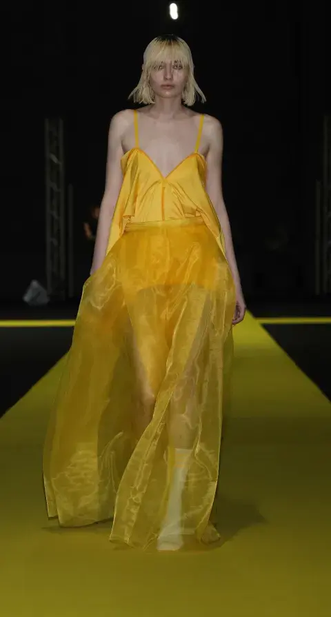 Una mujer en la pasarela de Designers con un vestido en color amarillo Una mujer en la pasarela de Designers con un vestido en color amarillo