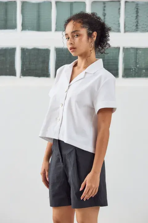 Foto de una modelo mujer usando una camisa blanca.