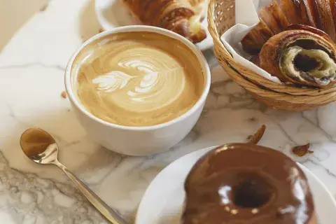 Un café con productos de pastelería Un café con productos de pastelería