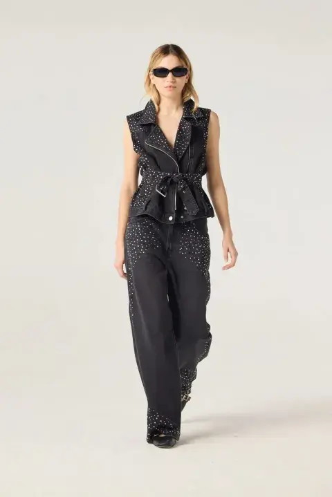 Una mujer usando un jean negro con apliques