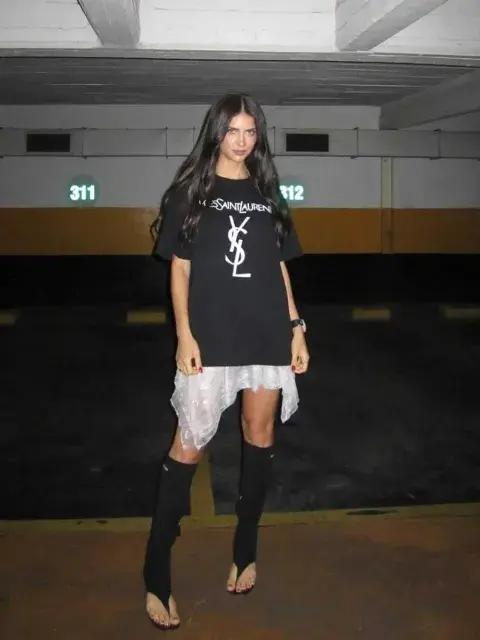 En el caso de Zaira eligió llevarlas con una remera oversize negra de algodón, con la inscripción de la marca Yves Saint Laurent, y una falda blanca con ruedo irregular de encaje y transparencias En el caso de Zaira eligió llevarlas con una remera oversize negra de algodón, con la inscripción de la marca Yves Saint Laurent, y una falda blanca con ruedo irregular de encaje y transparencias