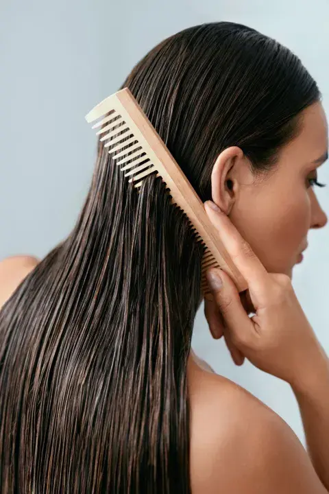 una mujer peinandose el pelo después de darse un baño una mujer peinandose el pelo después de darse un baño