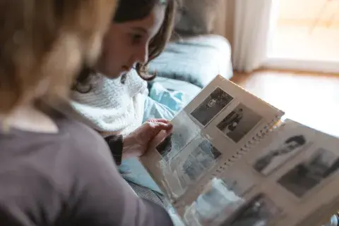 Niña y abuela miran un álbum de fotos Niña y abuela miran un álbum de fotos