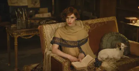 Una mujer transgénero sentada en un sillón con un libro entre las manos. Una mujer transgénero sentada en un sillón con un libro entre las manos.