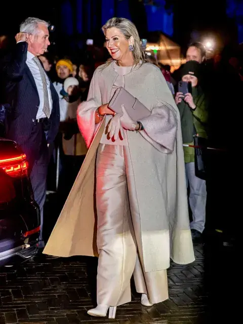 Máxima luciendo un pantalón de corte palazzo muy amplio y satinado y un jersey de punto con mangas campana Máxima luciendo un pantalón de corte palazzo muy amplio y satinado y un jersey de punto con mangas campana