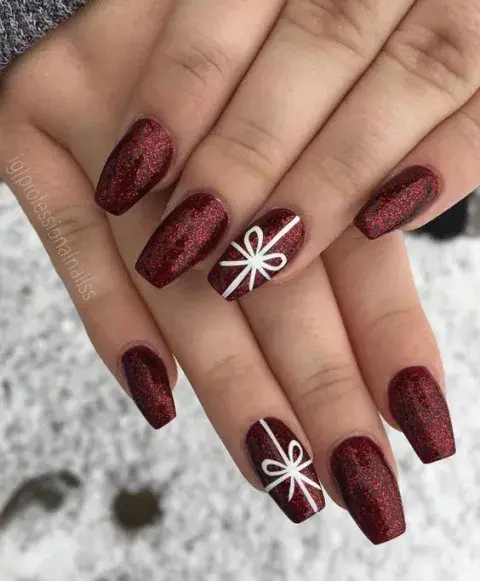 Uñas en color cherry y moños Uñas en color cherry y moños
