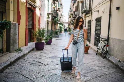 Foto de mujer paseando con una valija. Foto de mujer paseando con una valija.